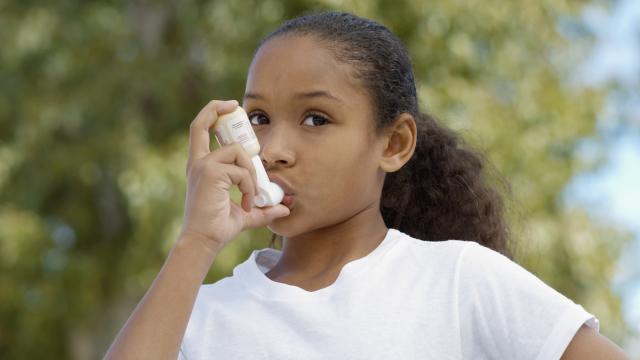 A child uses an inhaler outside